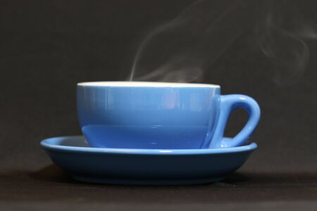Steaming coffee cup on dark background