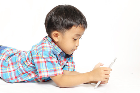 boy playing in a mobile phone on an isolated white backgroundの写真素材