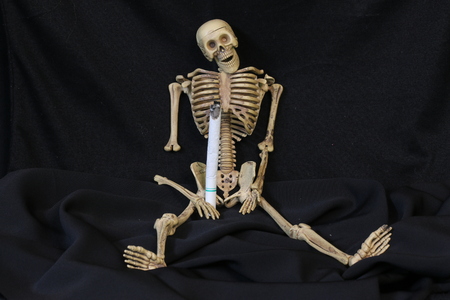 Three human skeletons with cigarettes.