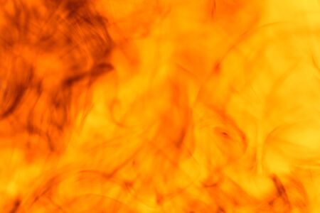 Black mixed red and yellow drip into the water.の写真素材