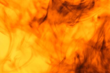 Black mixed red and yellow drip into the water.の写真素材