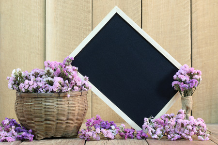 Blackboard with flowers on wooden floorの写真素材