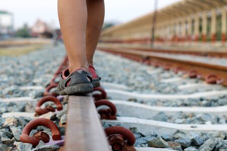 Boy walking on railroad tracksの写真素材