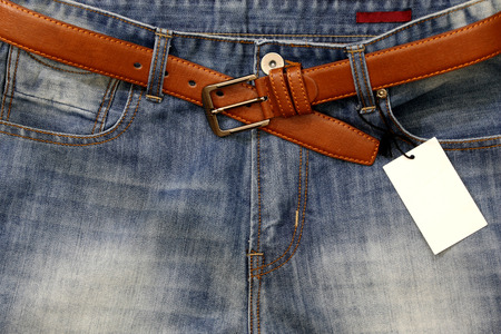Jeans with a price tag with a leather belt.