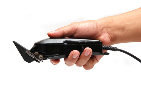 Arm holding hairclipper, isolated on white background, an electric hair clipper in hand for hairdressers, The barber clippers instead of scissorsの写真素材