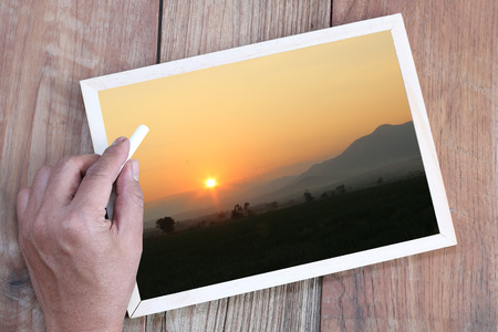 Beautiful nature in a wooden frame with a hand was burned.の写真素材