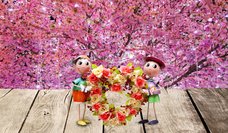 Doll male - female hearts and flowers on a wooden background flowers.の写真素材