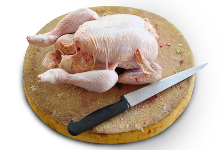Fresh chicken on the cutting board and knife isolated on white, with clipping path.の写真素材