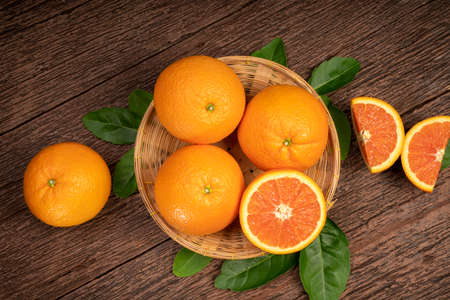 Fresh Oranges with Oranges slices on wooden Background, Grapefruit or Cara Cara orange with leaves in Wooden background.の写真素材