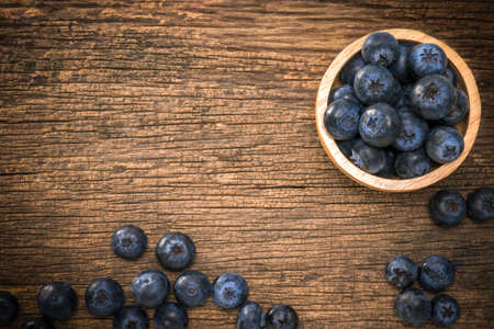 Fresh Blueberries in wooden bowl on the wooden table, Sweet Blueberry raw berries on wood background.の写真素材
