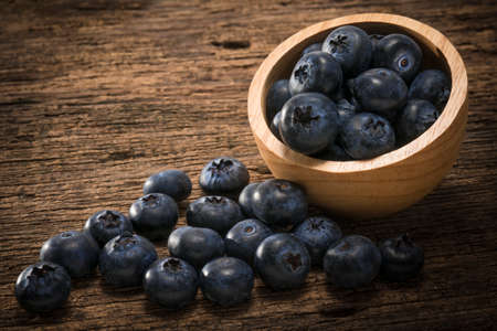 Fresh Blueberries in wooden bowl on the wooden table, Sweet Blueberry raw berries on wood background.の写真素材