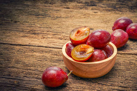 Prunes on a wooden background, Fresh Plums on the wooden tableの写真素材