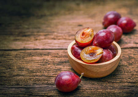 Prunes on a wooden background, Fresh Plums on the wooden tableの写真素材