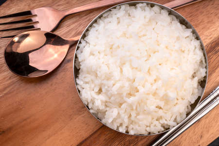 Rice in Korean rice bowl on wooden background, Cooked Korean rice in a metal bowl on wooden table.の写真素材