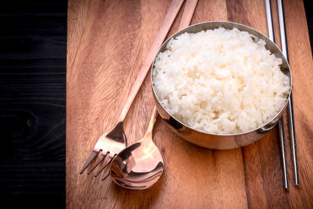 Rice in Korean rice bowl on wooden background, Cooked Korean rice in a metal bowl on wooden table.の写真素材