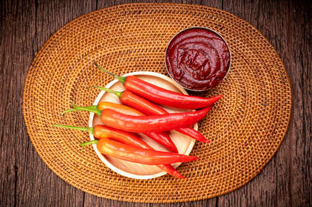 Korean pepper paste and red pepper in wooden plate, Gochujang Korean traditional Chili paste on a wooden table background.の写真素材