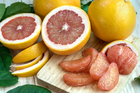 Fresh Grapefruit with Grapefruit slices and leaves in Wooden background, Fresh Grapefruit on wooden Background.の写真素材