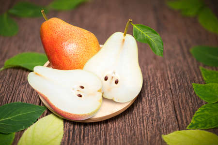 Fresh Pears with leaves on  a wooden background, Red Pears fruits delicious and sweet on wooden plate in wooden Backgroundの写真素材