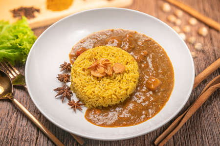 Curry chicken with yellow rice on plate over wooden background, Chicken with basmati riceの写真素材