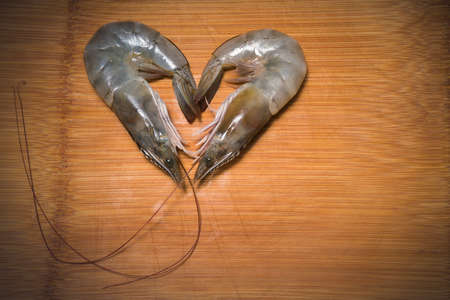fresh shrimps or prawns raw on wooden board ,fresh white shrimps in wooden background.の写真素材