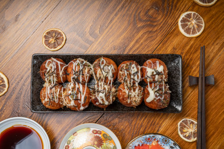 Japanese cuisine Takoyaki octopus balls with takoyaki sauce on wooden table, Traditional Japanese food.の写真素材