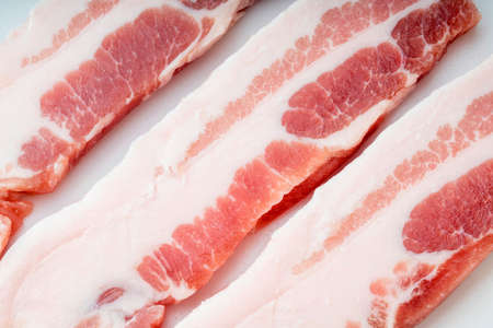 Streaky pork isolated on white background, Slide pork belly raw or Raw sliced bacon on white background with clipping path.の写真素材