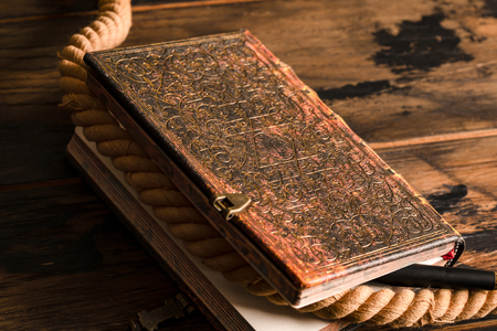 Vintage book with a star of David pattern. Marine rope and pen are on the notebook with a lock.の写真素材