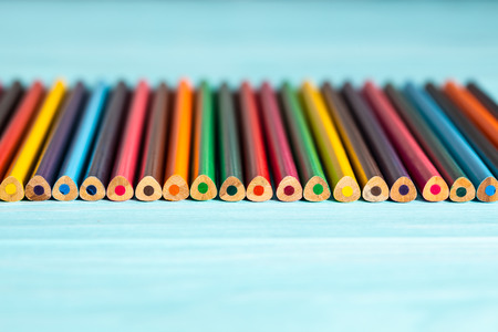 Colored pencils of all colors of the rainbow are on the table.