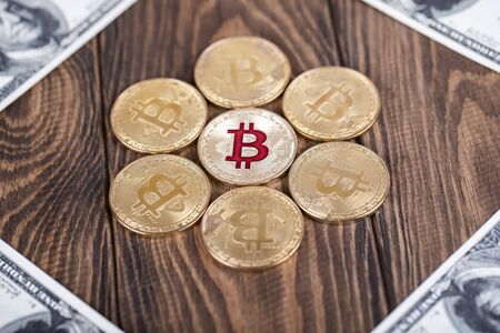 The cryptocurrency Bitcoin coin. Gold coin. 100 dollar bills lie in the corners.の写真素材