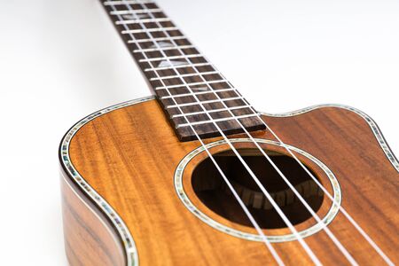 Ukulele on a white background. Hawaiian guitar lies on the table.の写真素材