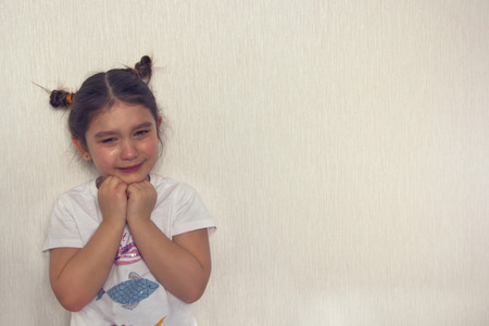 Little girl is crying on a white backgroundの写真素材