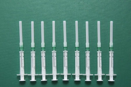 disposable syringes on a green backgroundの写真素材