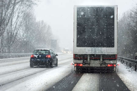 Winter day, snowfall in Germany. Track with a big wagon on the roadの写真素材