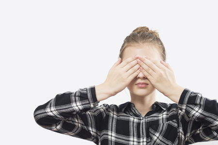 I cant see you -- Young Women is covering her eyes with her hands.Young beautiful girl closing her eyes with her hands. On a white background.の写真素材