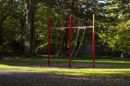 children's high swing in the summer city park, rocking alone without peopleの写真素材