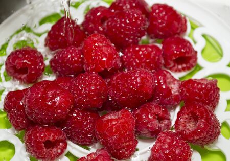 Ripe juicy raspberry with water droplets. Washing berries. Preparation of berries for use.