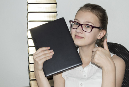 New technologies, people, Girl teenager chooses new technologies in replacing a large heap of encyclopediasの写真素材
