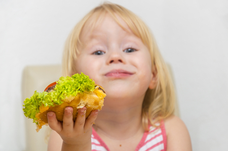 Happy hungry child eating healthy vegan burger.の写真素材