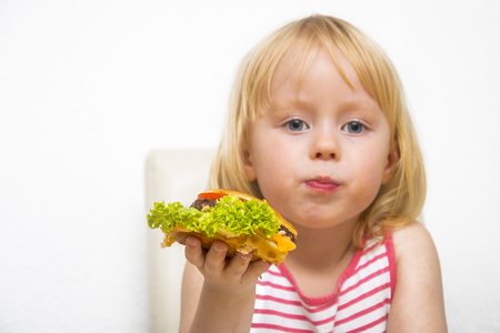 Happy hungry child eating healthy vegan burger.の写真素材