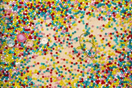 bright beads scattered on a wooden surfaceの写真素材