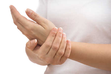 pain in joints, female hands close-up on white backgroundの写真素材