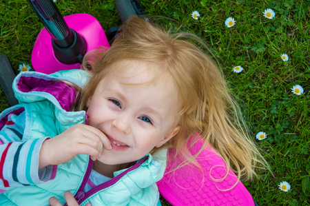 girl lying on the grass and laughingの写真素材