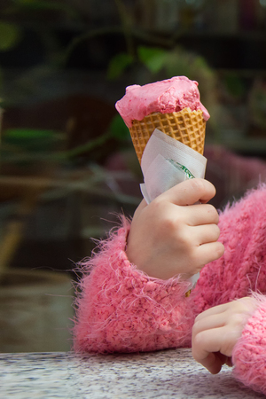 child holds ice cream in waffle cone