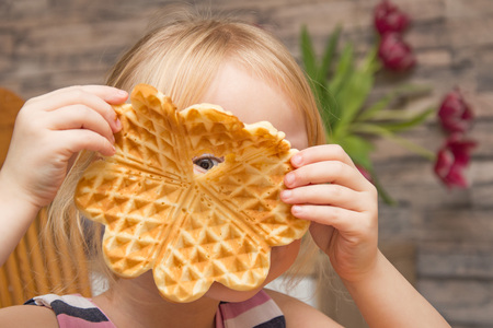 The child eats Belgian waffles.の写真素材