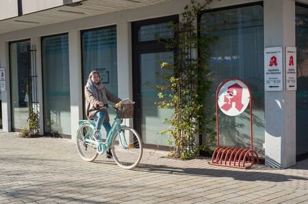 03/29/2019 Germany, the city of Kamen NRW young girl in the spring on a bicycle near the city pharmacy.のeditorial素材