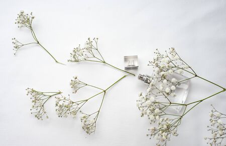 figured bottle of perfume on a white background next to flowers. concept of perfume, floral aromasの写真素材