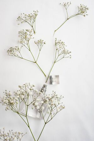 figured bottle of perfume on a white background next to flowers. concept of perfume, floral aromasの写真素材