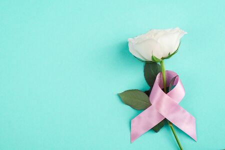 Pink ribbons with white rose on a blue background, Symbolic logo icon concept raising awareness campaign on female people living with breast cancerの写真素材