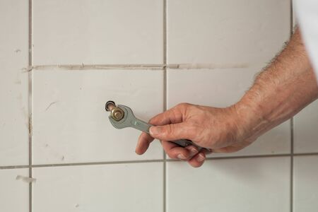 repair and rebuilding bathroom, unscrewing screws from the wallの写真素材