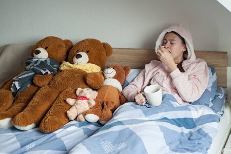teenager girl with cold symptoms at homeの写真素材